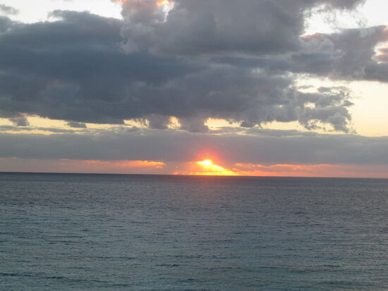 Sonnenaufgang über dem Meer bei Bewölkung