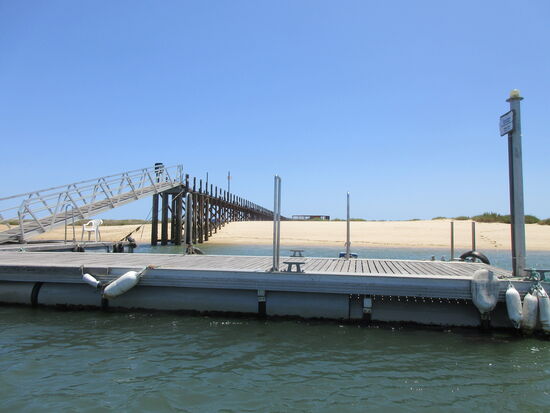 Anlegestelle für die Boote und Weg auf Pfählen zum Strand