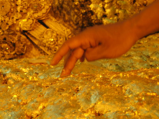 Ein Glaeubiger beim Goldplaettchen kleben