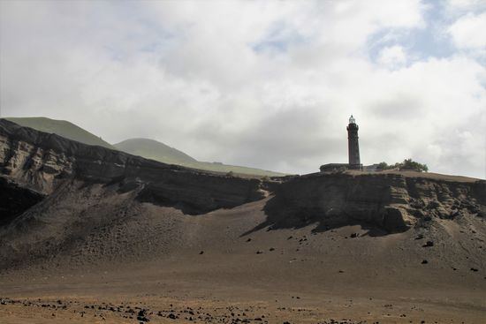 Wir laufen über die schwarze Erde, auf der überall Lavabrocken liegen - hochgradig beeindruckend.