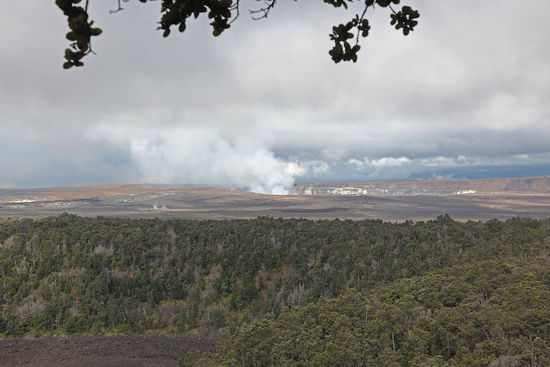 Kilauea Caldera? Wo? Man muss schon genau hinschauen, um die Ausmasse der Caldera zu begreifen. Der Gipfel des Kilauea ist so flach, dass man den Steilabhang der Caldera nicht auf Anhieb entdecken kann. Die Caldera hat einen Durchmesser von über 2km. In der Caldera liegt der Halema'uma'u-Krater mit einem Durchmesser von etwa 500m und im Halema'uma'u liegt der kleine Lavasse, aus dem die Rauchsäule aufsteigt.
