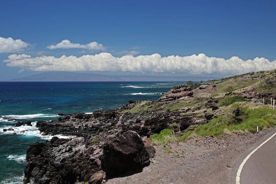 Die schmale Strasse nach Ost-Moloka'i windet sich entlang der teilweise schroffen Küste. Herrliche Aussichten gibt es zuhauf: hier mit der Insel Lana'i im Hintergrund.