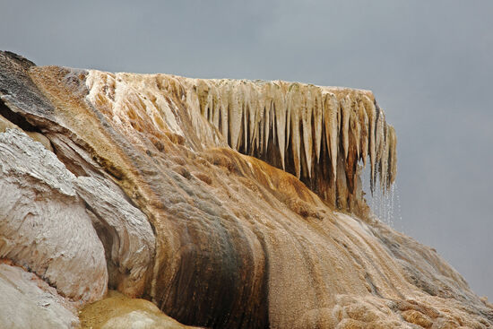 Das kalkhaltige, heisse Wasser der Quellen in Mammoth Hot Springs bildet in der Regel sehr schöne Sinterterrassen aus. Vereinzelt bilden sich an überhängenden Terrassen jedoch diese Säume von Stalaktiten.