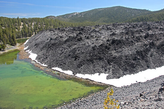 Endmoräne? Denkste!
Sieht aus wie eine Endmoräne oder eine Gletscherzunge. Hier haben wir jedoch das Ende eines Lavaflusses vor uns. Das besondere an dieser Lava ist, dass sie aus schwarzem Glas besteht. Obsidian nennt man dieses edle Material, das für Speerspitzen, Pfeilspitzen und sonstige Klingen, aber auch als Zahlungsmittel und als Schmuck bei den amerikanischen Ureinwohnern bekannt und beliebt war.