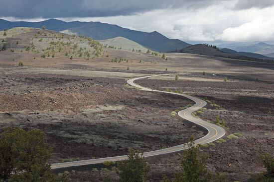 The Lond and Winding Road
Am Rande des Craters of the Moon National Monument ist ein kleines Strassennetz gebaut worden, um der Öffentlichkeit die Wunder dieses Landstriches etwas näher zu bringen. Man kann nicht vielen Menschen zumuten, 20km für eine schöne Aussicht zu Fuss zu gehen, daher hat man dort meist eine schöne Aussicht auf eine Strasse.