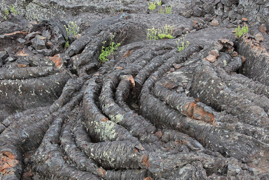 Stricklava - hier im Craters of the Moon National Monument in Idaho - ist weltweit an vielen Vulkanen anzutreffen. Sie entsteht, wenn die gerade erstarrende, dünnflüssige Lava an der Oberfläche zäh wird, in der Tiefe aber noch schneller weiterfliesst. Die zähe Oberfläche wird dabei wie eine Gardine in Falten gelegt.