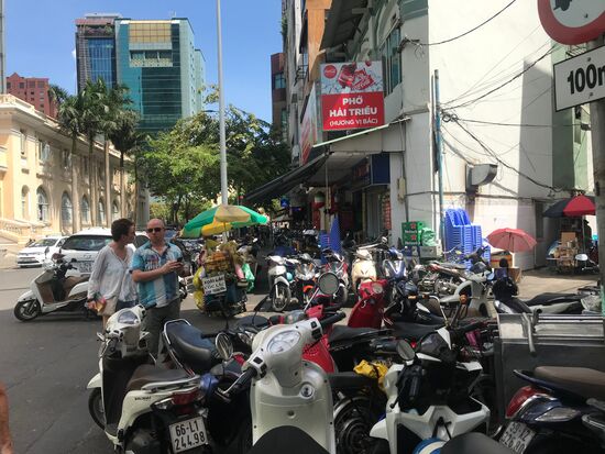 Typisches Straßenbild. Die Mopeds befahren nicht allein die Fußwege, sondern werden auch von diesen zugeparkt, sodass der Fußgänger oft nur auf die Straße ausweichen kann.