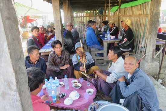 Die Männerecke:  Zum Frühstück gibt es gegrillte Ratte am Spieß mit Reisschnaps, der aus Fässern in Wasserflaschen gefüllt dazu serviert wird.