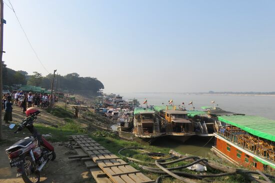 Am Hafen von Mandalay, dort wo die Waren abgefertigt werden, Transport- und Passagierschiffe an- und ablegen. Die Hafenarbeiter kommen mit ihren Familien zumeist aus den Bergregionen und lassen sich hinter den Kais in dürftig gebauten Hütten nieder.