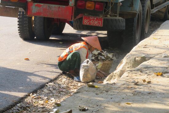 Frauen bei Reinigen der Straße . Eine organisierte Abfallbeseitigung seitens des Staates gibt es in Myanmar nicht.