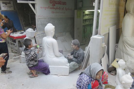 Mandalay ist bekannt und berühmt für traditionelles Handwerk. Generation für Generation wird die Kunst und Technik weitergegeben. In ganzen Straßenzügen konzentriert sich ein Handwerk. Wir sind bei den Steinmetzen. Vor allem die Kinder müssen die staubintensive Arbeit des Steinfräsens übernehmen und sehen dann selbst wie weiße Statuen aus. Kinderschutz existiert in Myanmar nicht, auch wenn die Alphabetisierung recht hoch ist, viele Kinder aus armen Familien werden eher zum Arbeiten für den Familienunterhalt als zum Lernen in die Schulen geschickt.