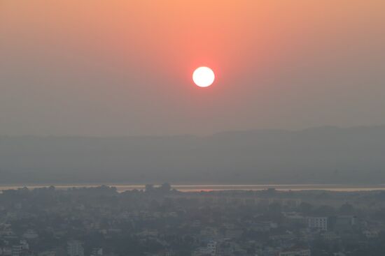 Sonnenuntergang auf den Mandalay Hills nach einem langen Tag, vielen unvergesslichen Eindrücken und schönen Begegnungen. Wir sehn den roten Sonnenball am Horizont untergehen und genießen den  einzigartigen 
Rundblick auf die sehr gründe Stadt.