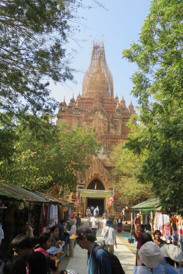 Auf dem Weg nach Bagan besuchen wir die Htilominlo Pagode, 46 Meter hoch, quadratisch aufgebaut und mit vielen Wandmalereien verziert. Schon von weitem ist lautes, monotones Beten zu hören. Wir werden aufgeklärt, dass ist kein Band. Das Beten erfolgt durch Mönche, abwechselnd, weil Arbeiter auf dem Turm Reparaturarbeiten vollziehen. Um die Arbeiter vor Unheil zu schützen, wird ununterbrochen gebetet. Selbstverständlich beziehen die Mönche die Besucher in ihr Wohl mit ein.