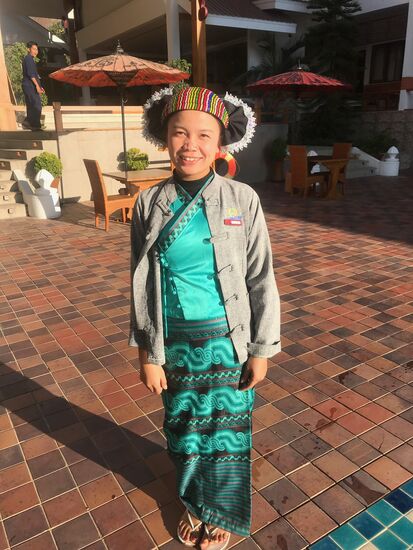 Shan Frau mit Wickelrock und farbigem Kopfschmuck.