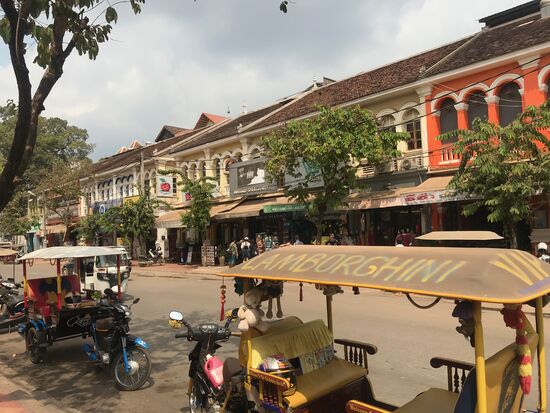 Die Tuktuks im Vordergrund, Mopedtaxis bieten überall im Stadtgebiet ihre Dienste an und bringen den Besucher gern für wenig Geld zum gewünschten Ziel.
