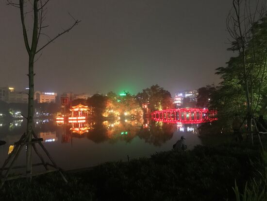 Der Hoan Kiem See am Abend  mit Blick auf den Jadebergtempel.  Der Name des Sees vom "zurückgegebenen Schwert" ist mit einer schönen Legende verbunden: Eine goldene Schildkröte aus dem See soll einem Fischer ein Schwert gegeben, mit dem Eindringlinge aus dem Land erfolgreich vertrieben werden konnten. Nach Rückkehr des Königs  hat der Fischer das Schwert voller Dankbarkeit  der Schildkröte im See zurückgegeben. Die Menschen gehen daher davon aus, dass das Schwert weiterhin am Boden des Sees liegt. Die Schildkröte wird seither verehrt mit dem eigens dafür in der Mitte des Sees errichtetem Schildkrötenturm. Die Schildkröte von einst und eine im Jahr 2016 aus dem See entnommene  Schildkröte können im Jadebergtempel am Nordufer des Sees bewundert werden. Von der rot beleuchteten Holzbrücke zum Tempel kann bei schönem und klarem Wetter der Sonnenaufgang beobachtet werden.