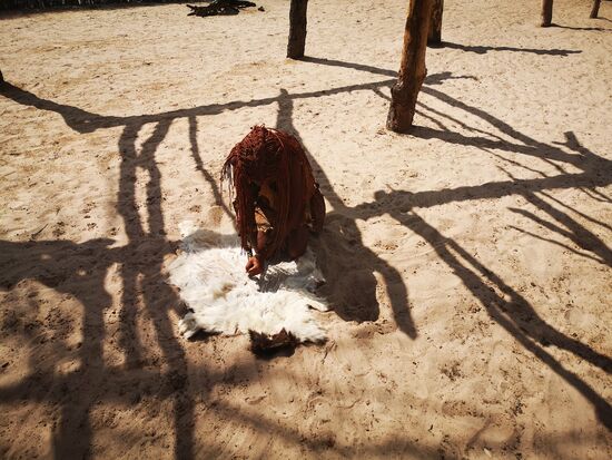 Im Mbunza Dorf: Ziegenfell wird für die Herstellung von  Kleidung enthaart.
