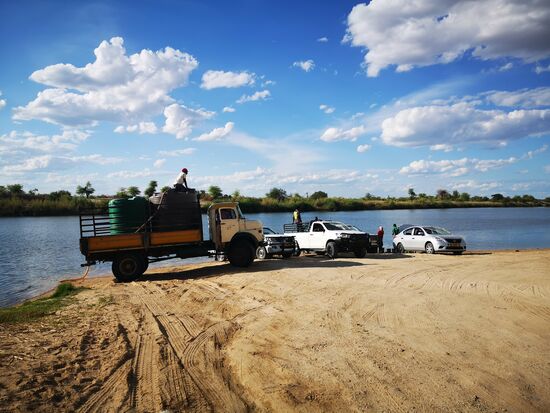 Pausenloses Wasserschöpfen am Okavango in Rundu. Hier bildet der Fluss die Grenze zu Angola, doch der Grenzverkehr ist sehr lebendig. Wir haben immer wieder  Boote hin und her fahren sehen. Uns wurde berichtet, dass Angolaner gern in Namibia einkaufen bzw. ihre Kinder auf die Schule schicken.