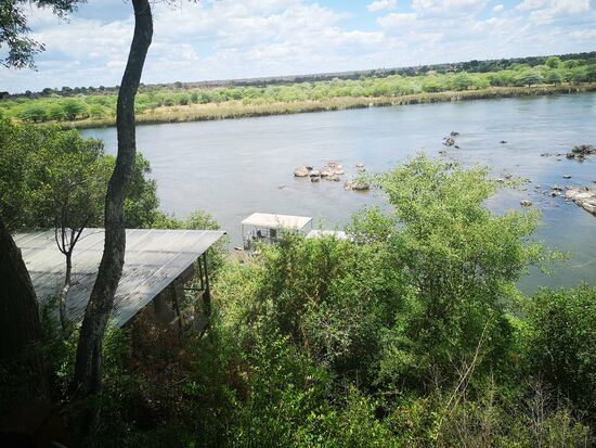 Blick auf den Okavango von unserer Frühstücksterrasse aus. Auch zum Einschlafen vom Bett aus und von der Dusche bot sich uns dieser phantastische Blick auf den Okavango und das angolanische Ufer.