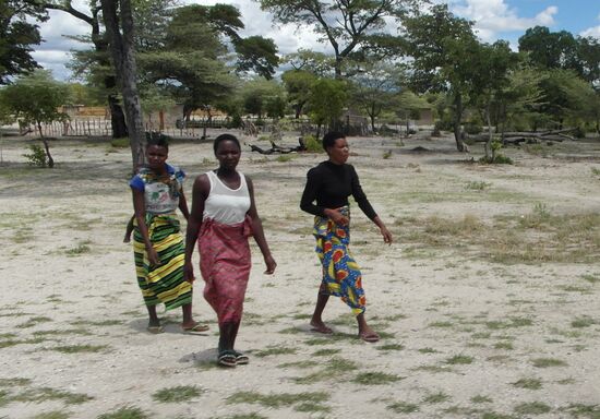 Buntgekleidete Frauen auf dem Gang zur Kirche.