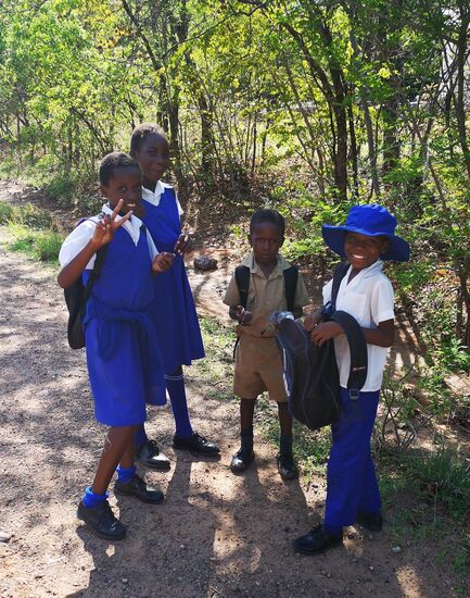 Kinder in ihren schmucken Schuluniformen in Victoria Falls auf dem Nachhauseweg am späten Nachmittag.