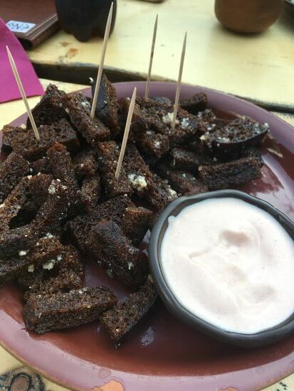 Leckeres Schwarzbrot aus Roggen, leicht süß und bisschen Kümmel drin, aber sehr lecker, wie hier mit Knoblauch und Dipp, wird hier und auch in Lettland sehr häufig gegessen