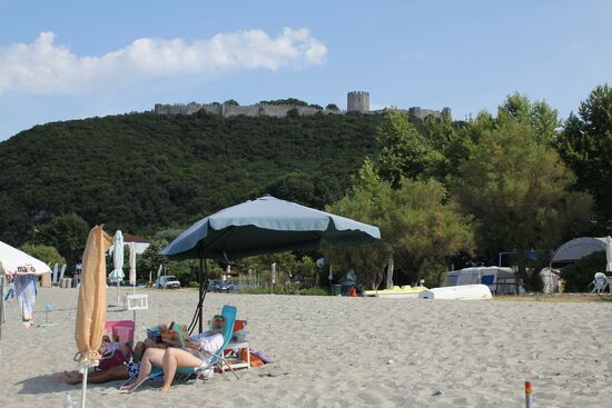 Auf dem Berg die Burgruine Platamon, vom Strand aus gesehen.