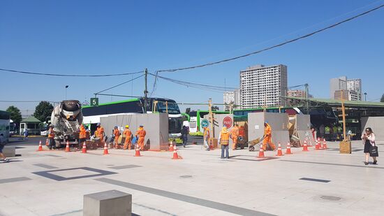 Dieses Bild muss kurz erklärt werden...Szene ist eine Baustelle am Busbahnhof. Links im Bild stehen Männer wie die Ameisen Schlange- um mit Zement beladen zu werden. In der Mitte des Bildes  stehen 2 weitere Bauarbeiter. Der Hintere regelt den Fahrgastverkehr vom Bus kommend, mit einem Stop Schild, damit die Ameisennmänner nach rechts auf die Baustelle laufen können. Der Baustellenmann mit dem roten Stoppschild der Mitte regelt 150cm gegenüber des anderen Stoppschildmannes den Verkehr der zum Bus gehenden Menschen. Wir fragen uns, warum es hier trotzdem so viele Arbeitslose gibt?!?!