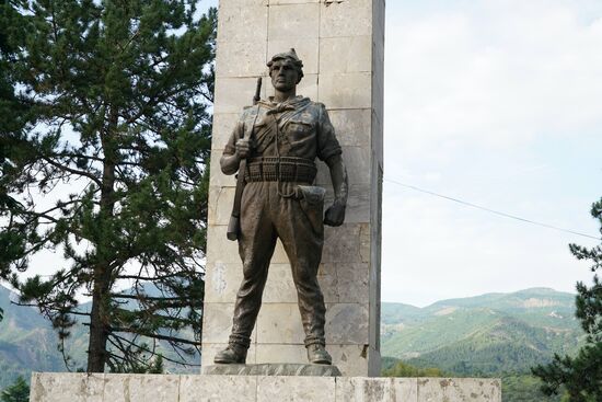 der gusseiserne Bauer in Soldatenkleidung sieht mit stoischer Miene über das Treiben in der Stadt hinweg