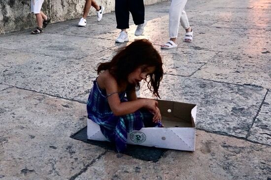 Kinder von Roma-Familien warten in ihren Kartons auf ein paar Münzen