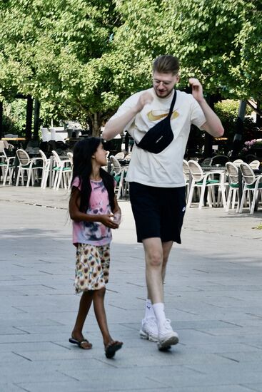 dunkelhäutige Kinder mit schwarzen Haaren laufen mit den Passanten mit und gucken sie mit traurigen Augen an, um etwas Geld zu bekommen