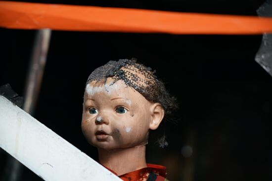 jemand hat die einzige Puppe, die das Inferno "überlebt" hat, an die Tür gestellt