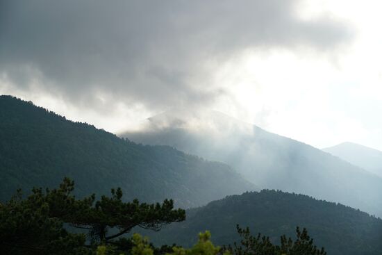 dicke, dunkle Wolken wabern über die Berge