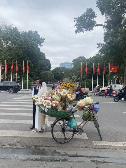 ein vietnamesisches Brautpaar vor der Statur des Ho Chi Minh