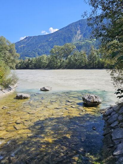 Ein Nebenfluss mündet im dreckigen Inn