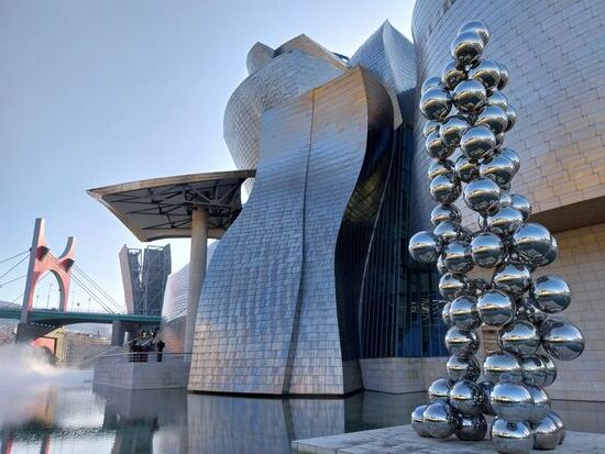 Guggenheim-Museumskomplex am Flussaufer des Nerviòn 
aus Titan, Sandstein und Glas,
rechts die Skulptur Tall Tree &amp; The Eye von Anish Kapoor
