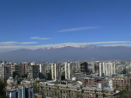 Der Blick von oben auf die Hauptstadt Santiago. Flankiert von den hohen Andengipfeln im Hintergrund.
The top view of Santiago the capital. Flanked by high Andes peaks in the background.