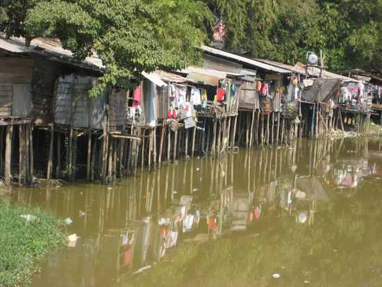 die Huetten der Einwohner am Fluss von Siem Reap