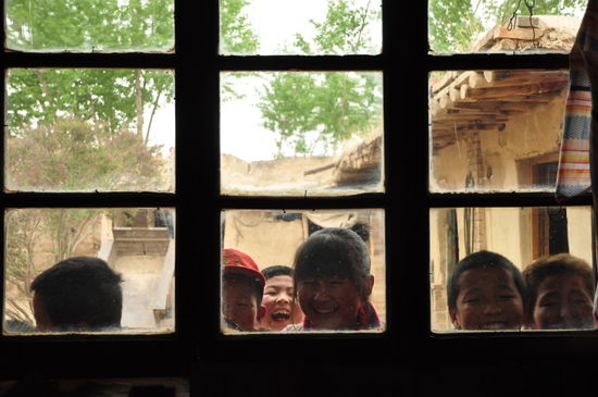 Neugierige Kinder schauen zum Fenster hinein