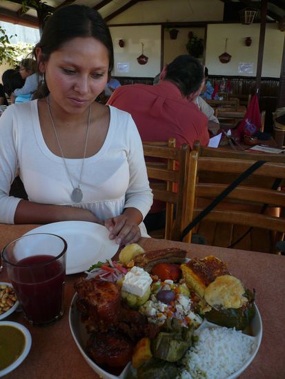 Mapi vor einem riesen Berg typischer Arequipenischer Gerichte (Kaesesalat, Rocoto Relleno, Lamm, Chicharon, Schweinebraten, Pastel de Papa und Beilagen)