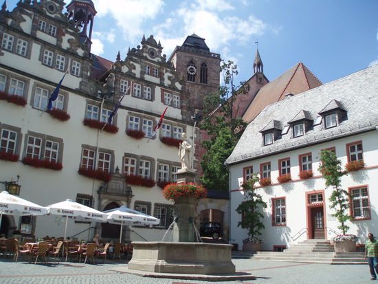 Das schöne Rathaus von Bad Hersfeld hat fünf Giebel. Davor befindet sich der Lullus-Brunnen. Zwischen den beiden Gebäuden gelangt man über eine kleine Treppe zur Kirche.