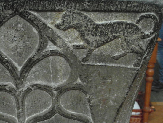 Am Taufbecken ist dieser Hund eingemeißelt