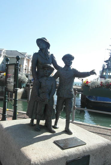 Eine Statur von Annie Moore und ihren Brüdern - sie segelten im Jahr 1891 von Cóbh nach New York und waren die allerersten Migranten, die über Ellis Island nach Amerika einreisten.