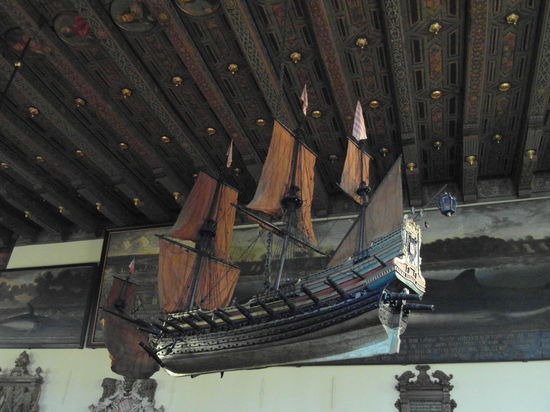 Von der Decke hängen große Modelle von Kriegsschiffen. Die Kanonen gaben früher bei Festen sogar tatsächlich Schüsse mit Schwarzpulver ab - und färbten die feiernde feine Gesellschaft schwarz, bis das Ganze verboten wurde!