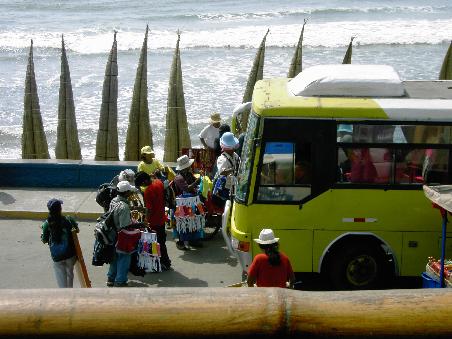 Aus dem Bus steigen gleich eine Menge neuer potentzielle Kaeufer aus Im Hintergrund lehnen die Boote der Tortora-Fischerboote an der Strandpromenade.