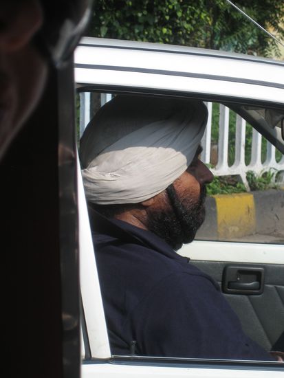 der Herr von heute traegt den Bart zur haelfte unterm Turban