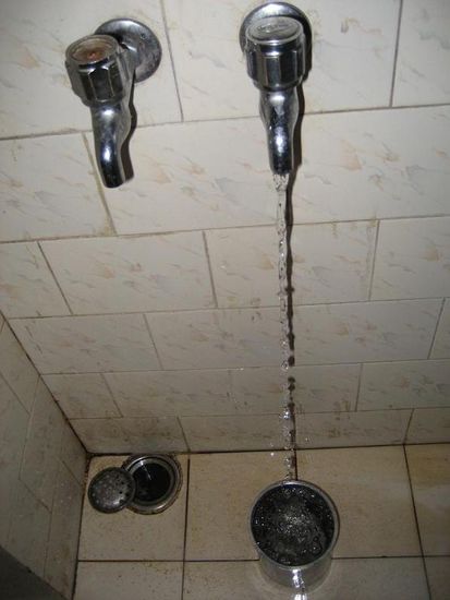 Ein Wasserhahn und ein kleiner Blecheimer bilden ein Duscherlebnis der frostigen Art