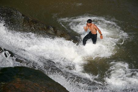 Thai beim Versuch den Wasserfall hinauszuklettern