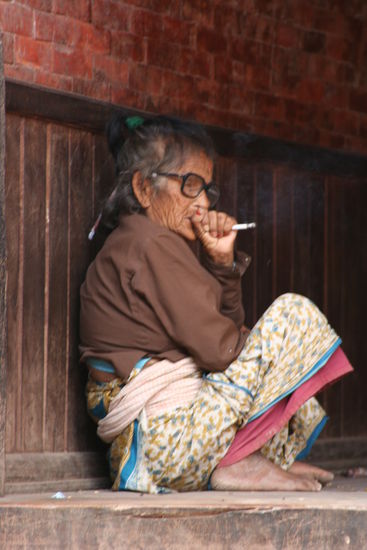 Grossmama raucht gemütlich eine Zigarettte.