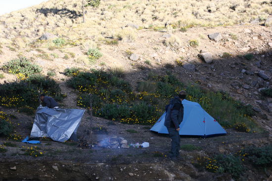 Unser Basecamp auf 3500 m. Hier haben wir übernachtet. Unser Führer Eusebio unter der kleinen Blache neben dem Feuer